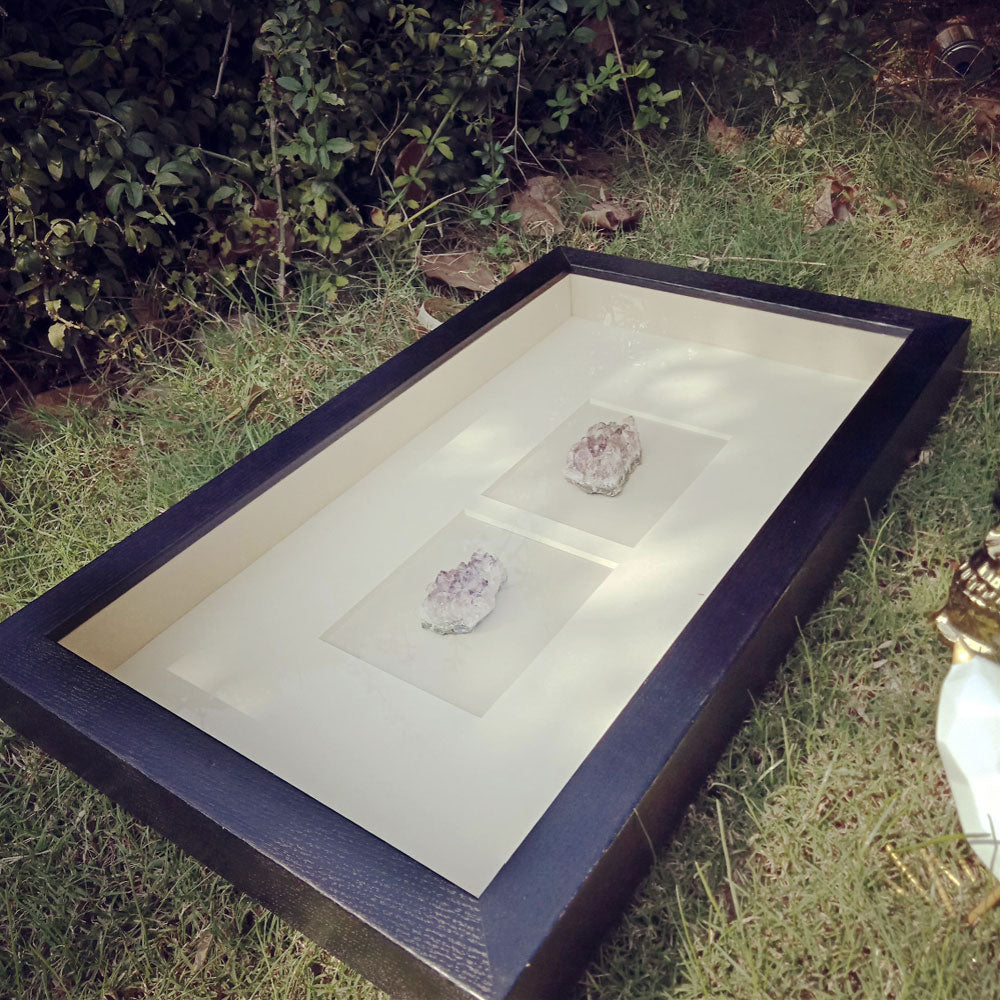 Hotel bedroom sofa background with black frame and purple crystal mineral shadow box